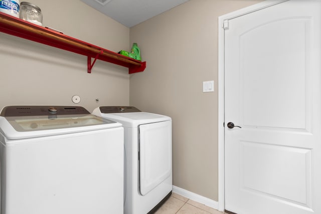 laundry room with washer and clothes dryer and light tile patterned flooring