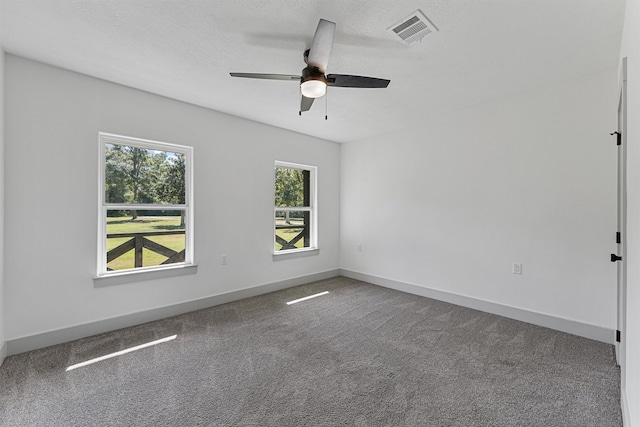 carpeted spare room with ceiling fan and a textured ceiling