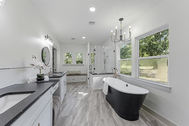 bathroom with vanity, a notable chandelier, and plus walk in shower