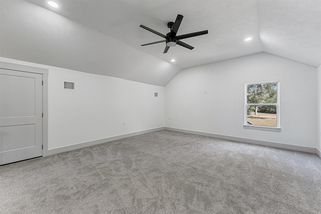 bonus room featuring lofted ceiling, a textured ceiling, carpet, and ceiling fan