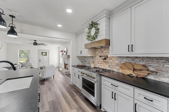 kitchen featuring hanging light fixtures, white cabinetry, ceiling fan, high end stove, and hardwood / wood-style flooring