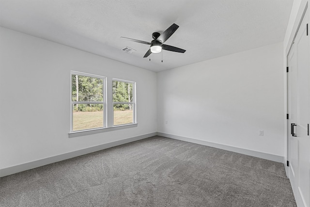 carpeted spare room with a textured ceiling and ceiling fan