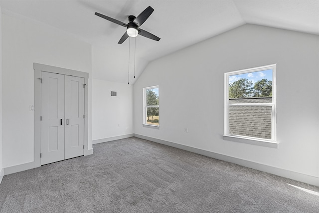 carpeted empty room with vaulted ceiling and ceiling fan