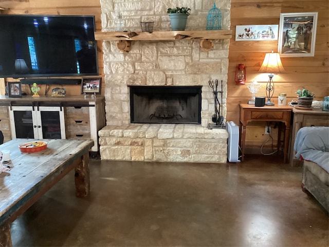 living room with wooden walls and a fireplace