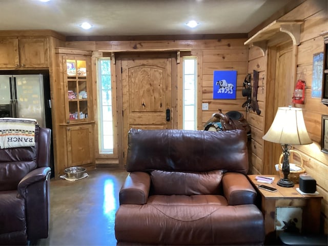 living room featuring wood walls and concrete flooring