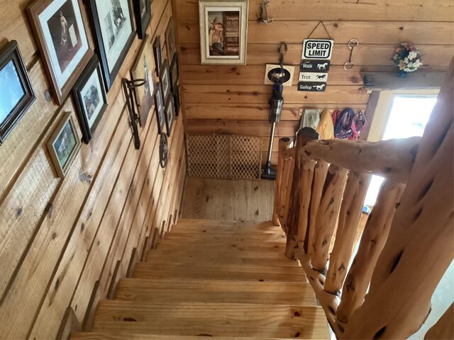 stairs with hardwood / wood-style flooring and wooden walls