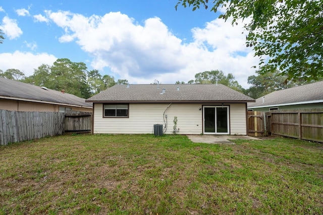 rear view of property featuring a patio, central AC, and a yard