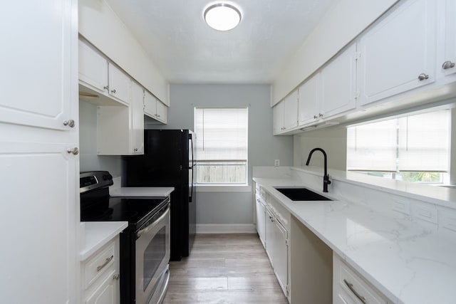 kitchen with white cabinets, sink, light wood-type flooring, and electric range