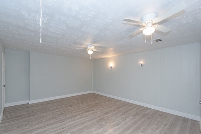 unfurnished room featuring ceiling fan, a textured ceiling, and light wood-type flooring