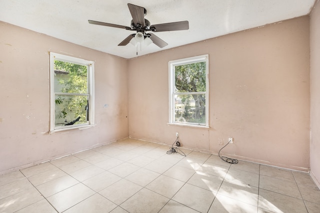 tiled empty room featuring ceiling fan