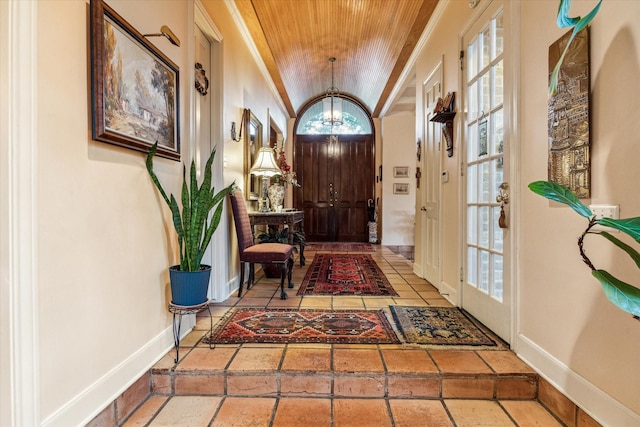 entryway with wood ceiling, baseboards, and ornamental molding