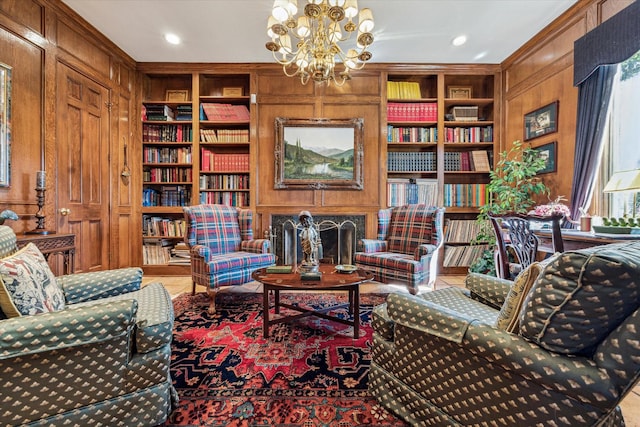 sitting room with tile patterned flooring, wood walls, built in shelves, a fireplace, and a notable chandelier