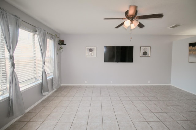 tiled spare room with ceiling fan and a wealth of natural light