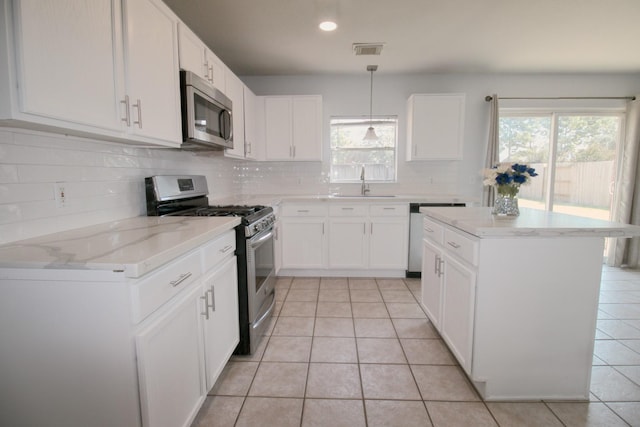 kitchen with sink, decorative light fixtures, white cabinetry, and appliances with stainless steel finishes