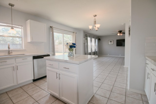 kitchen featuring a center island, stainless steel dishwasher, white cabinets, sink, and backsplash