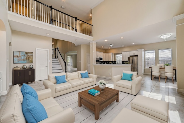 living room featuring ornate columns and a high ceiling