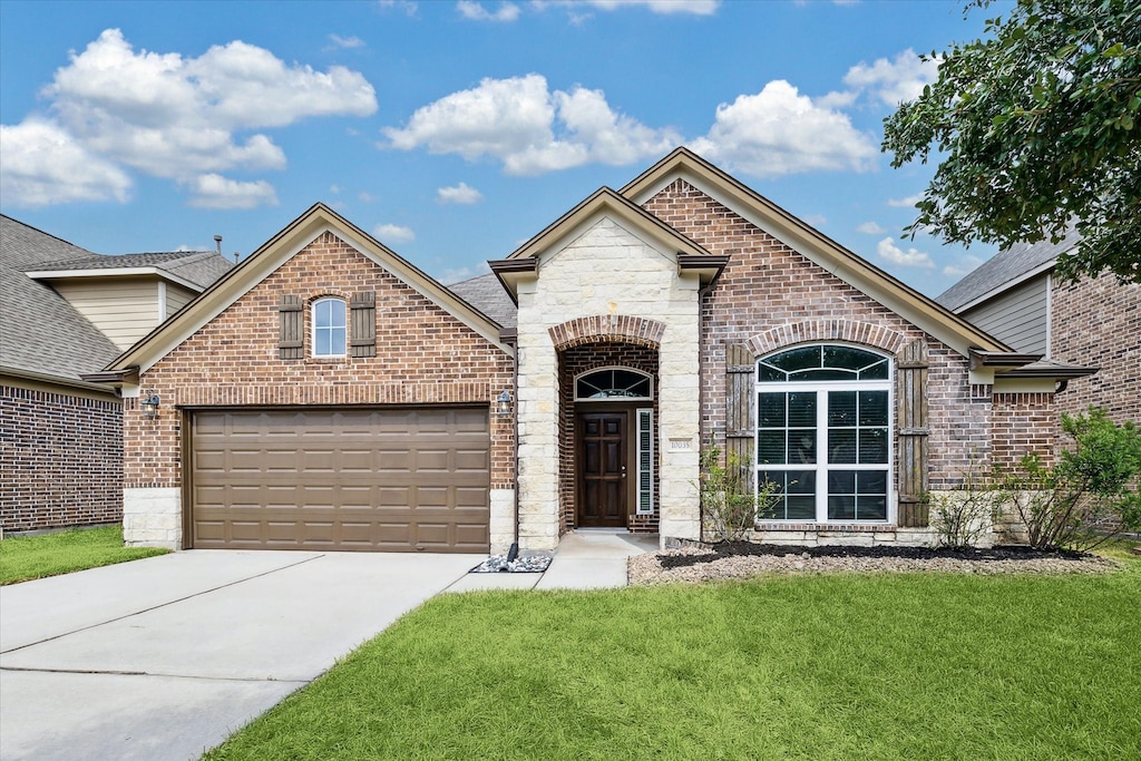 view of front of property featuring a front yard and a garage