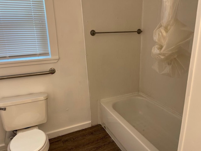 bathroom featuring hardwood / wood-style floors, shower / tub combo with curtain, and toilet