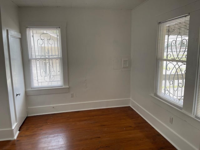 unfurnished room with dark hardwood / wood-style flooring and plenty of natural light