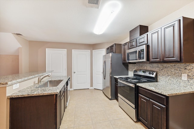 kitchen featuring dark brown cabinetry, stainless steel appliances, and sink