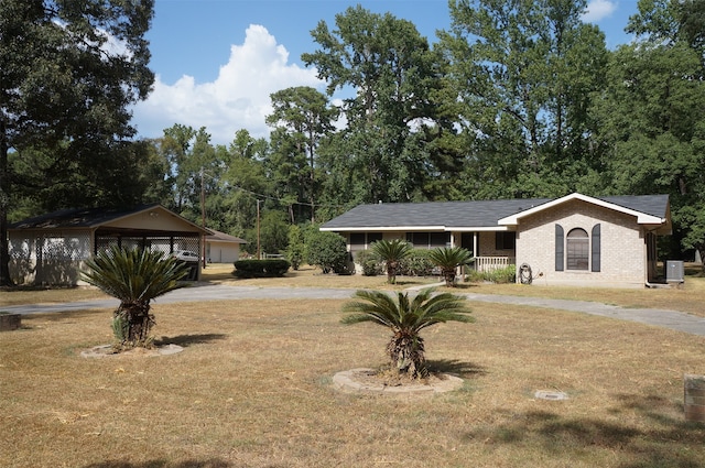 ranch-style house featuring a carport, a front yard, and a porch