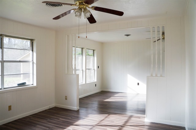 empty room with ceiling fan and dark hardwood / wood-style floors