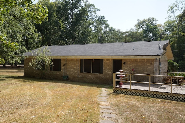 ranch-style home featuring a front lawn and a wooden deck