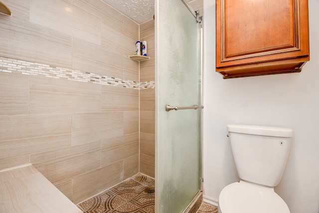 bathroom featuring toilet and a shower with shower door