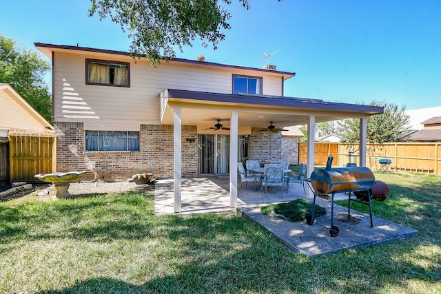 back of property with a patio area, ceiling fan, and a yard