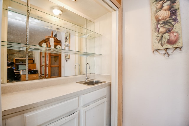 bar with white cabinets and sink