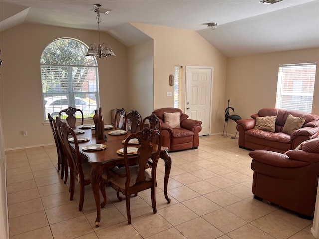 dining area featuring light tile patterned floors, vaulted ceiling, and an inviting chandelier