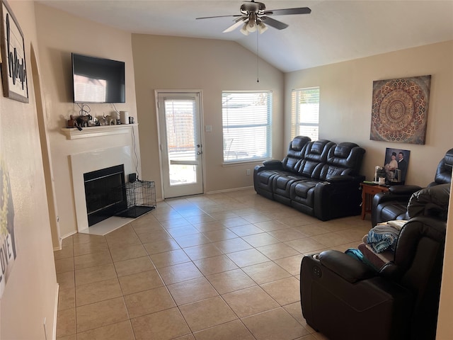 living room with lofted ceiling, ceiling fan, and light tile patterned floors