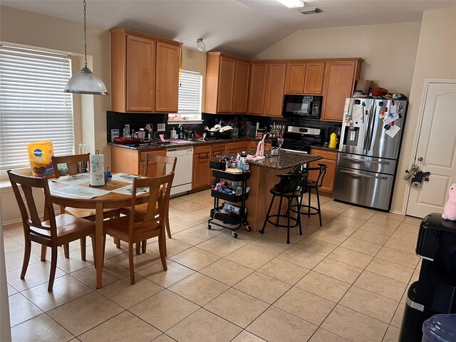 kitchen featuring appliances with stainless steel finishes, decorative backsplash, pendant lighting, and a kitchen island