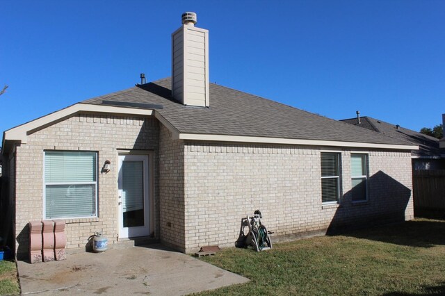 back of property with a patio and a yard