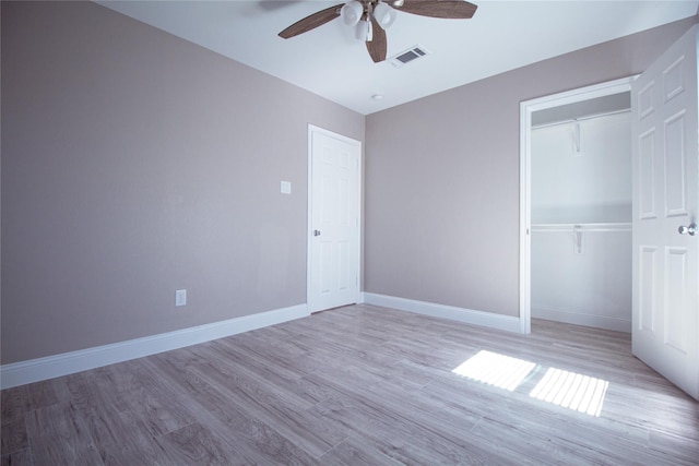 unfurnished bedroom featuring a closet, light hardwood / wood-style flooring, and ceiling fan