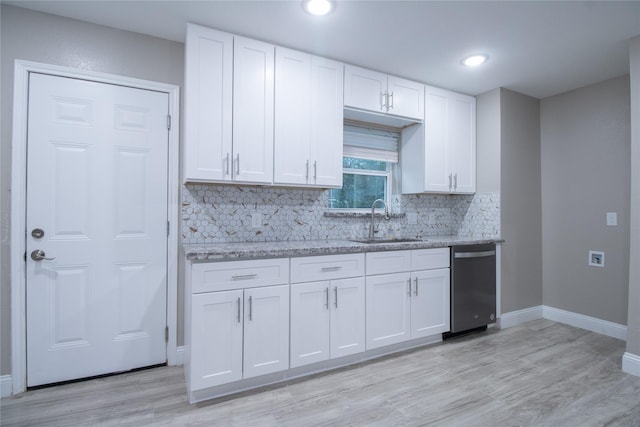 kitchen featuring white cabinetry, sink, light stone counters, stainless steel dishwasher, and backsplash