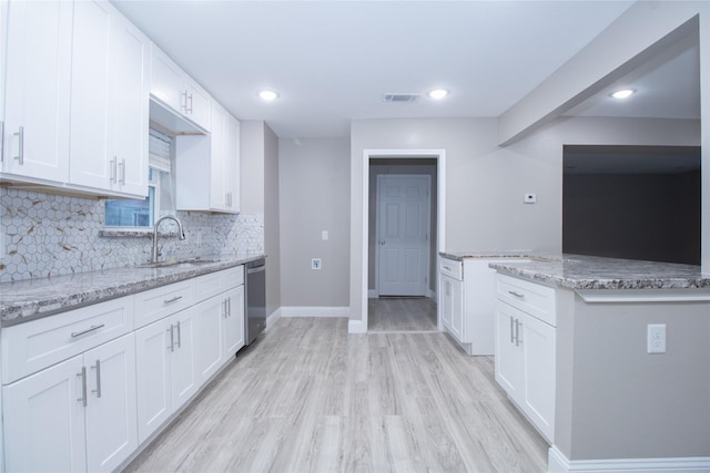 kitchen featuring dishwasher, light stone counters, white cabinetry, and sink