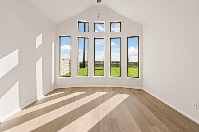 interior space with light hardwood / wood-style floors and high vaulted ceiling