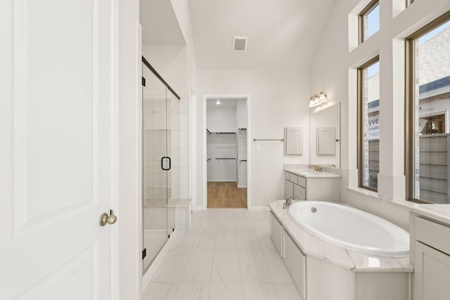 bathroom featuring lofted ceiling, vanity, and independent shower and bath