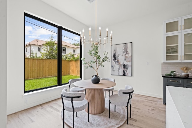 dining space with a chandelier and light hardwood / wood-style flooring