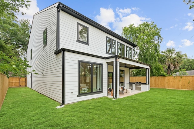 rear view of house with a lawn, area for grilling, and a patio area