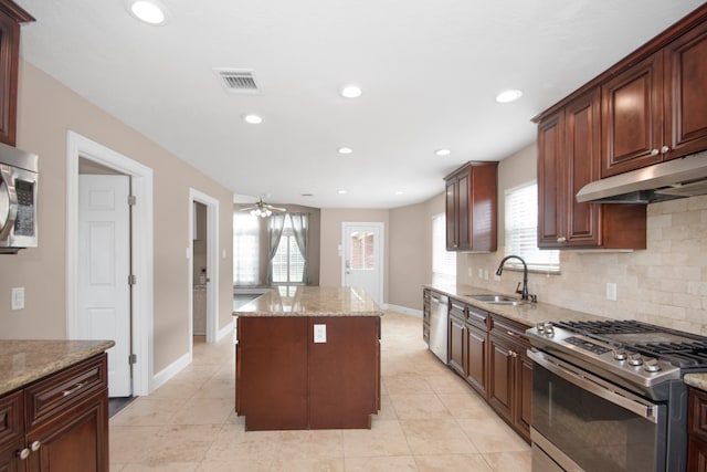 kitchen with sink, a healthy amount of sunlight, appliances with stainless steel finishes, and a center island