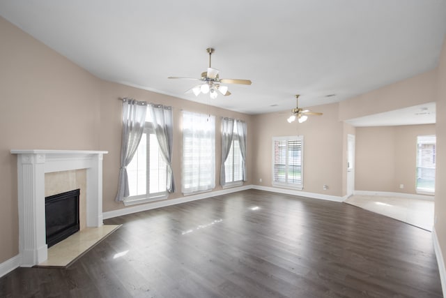 unfurnished living room featuring dark wood-type flooring and ceiling fan