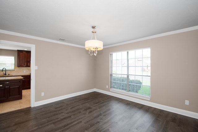 unfurnished dining area featuring a healthy amount of sunlight, hardwood / wood-style flooring, and ornamental molding