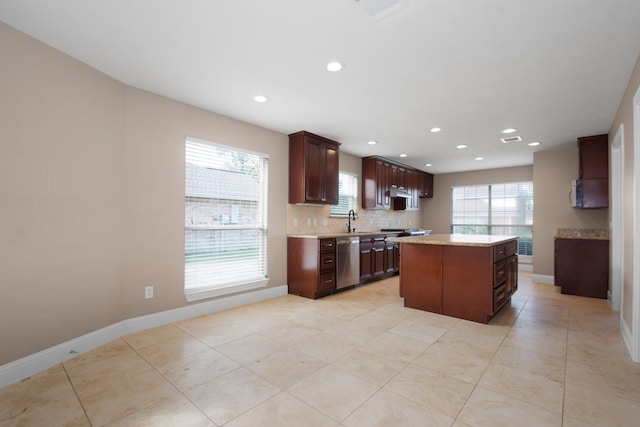 kitchen featuring decorative backsplash, appliances with stainless steel finishes, a wealth of natural light, and a kitchen island