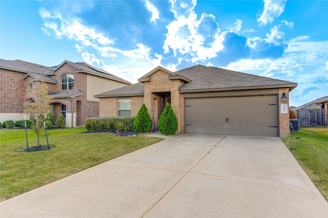 view of front of home with a front lawn, central AC unit, and a garage