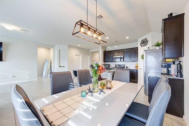 dining room with a chandelier and light tile patterned floors