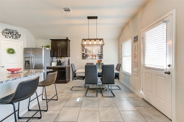 tiled dining room with vaulted ceiling