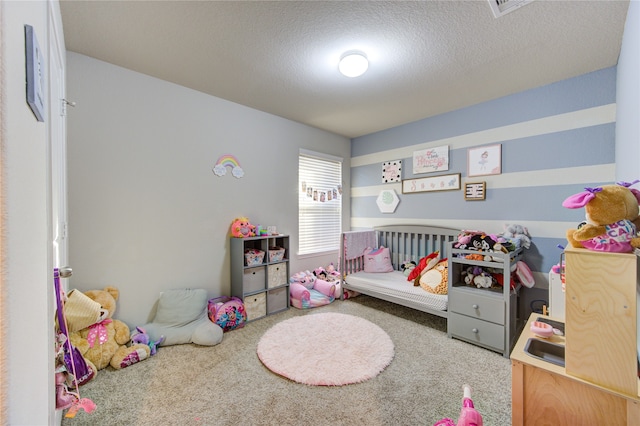 carpeted bedroom with a nursery area and a textured ceiling