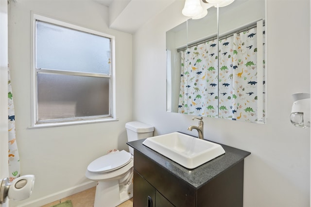 bathroom featuring toilet, vanity, and tile patterned flooring